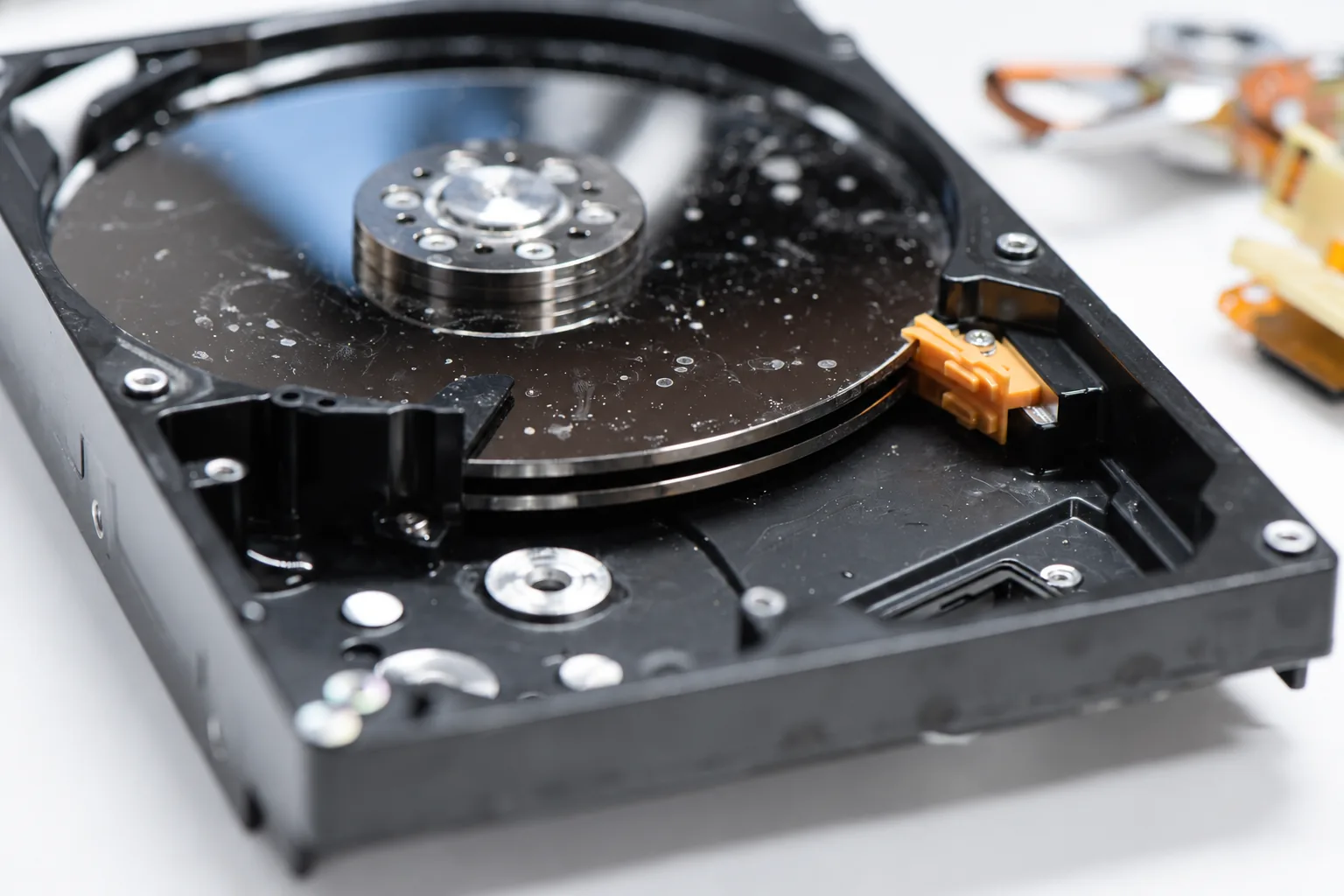 Side-angle view of contaminated hard drive platters showing residue across multiple recording surfaces